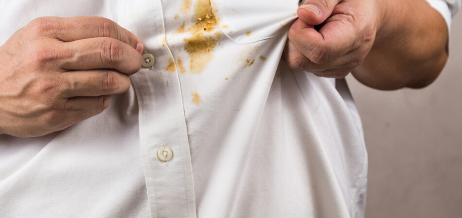Frustrated,person,pointing,to,spilled,curry,stain,on,white,shirt